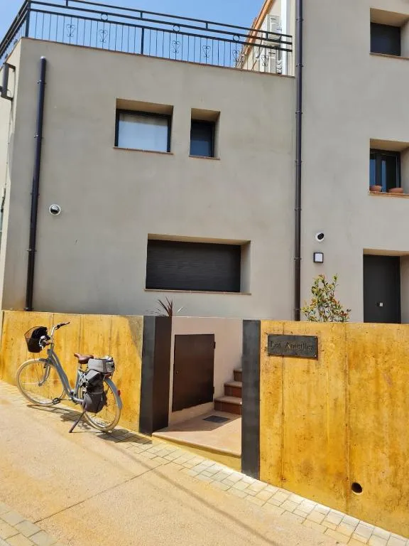 Façana de Les Ametlles al carrer de Masarac, amb el mur d’acer corten i una bicicleta recolzada